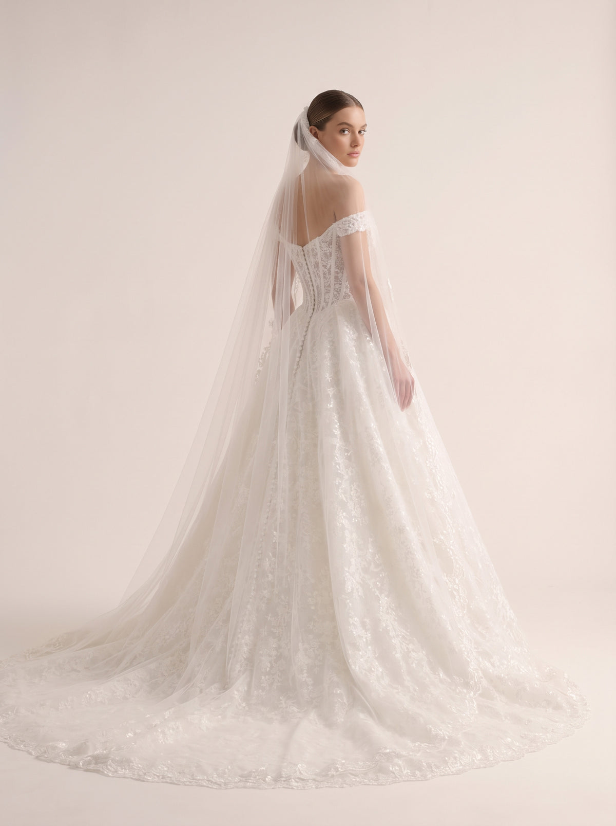 Thalia A-line wedding dress back view featuring zipper with button details and chapel train by Fiore's Bridal - Back View