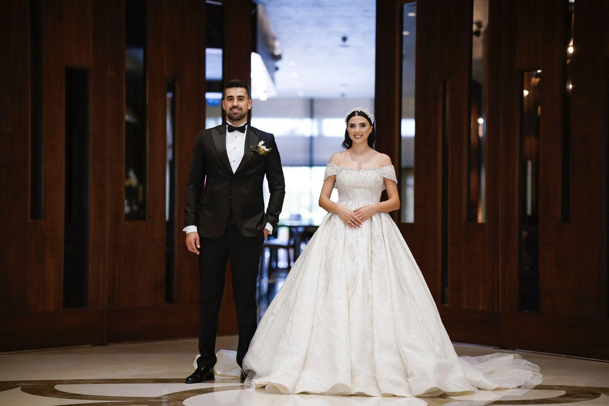 Öznur and Tunç on their wedding day, Öznur in an off-the-shoulder Fiore's Bridal ball gown